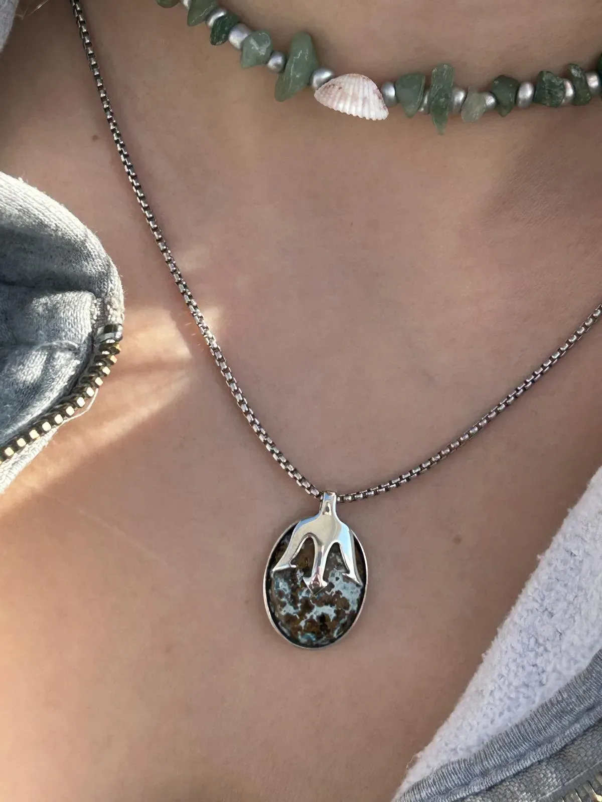 Getragenes Collier mit ovalem Anhänger aus Silber und Stein